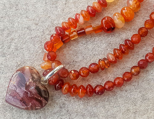 Long necklace out of red chalcedony, here as double short form, with exchangeable pendant made of petrified wood and silver