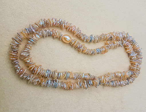 Lange Süßwasserperlkette Keshi mit einer ovalen Perle